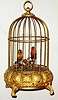 German pair of singing birds in a fancy bejeweled brass cage, 20th century