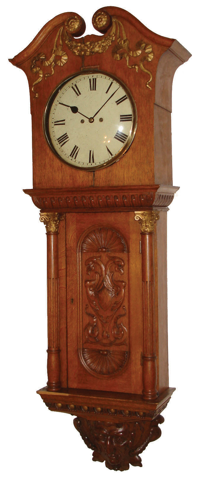 English carved wall clock, 8 days, time and strike, spring driven, double fusee movement in a well carved oak case with removable hood, full carved and reeded columns flanking carved trunk door, nicely carved North Wind base and painted iron dial, c1890 — Antique Clocks Price Guide