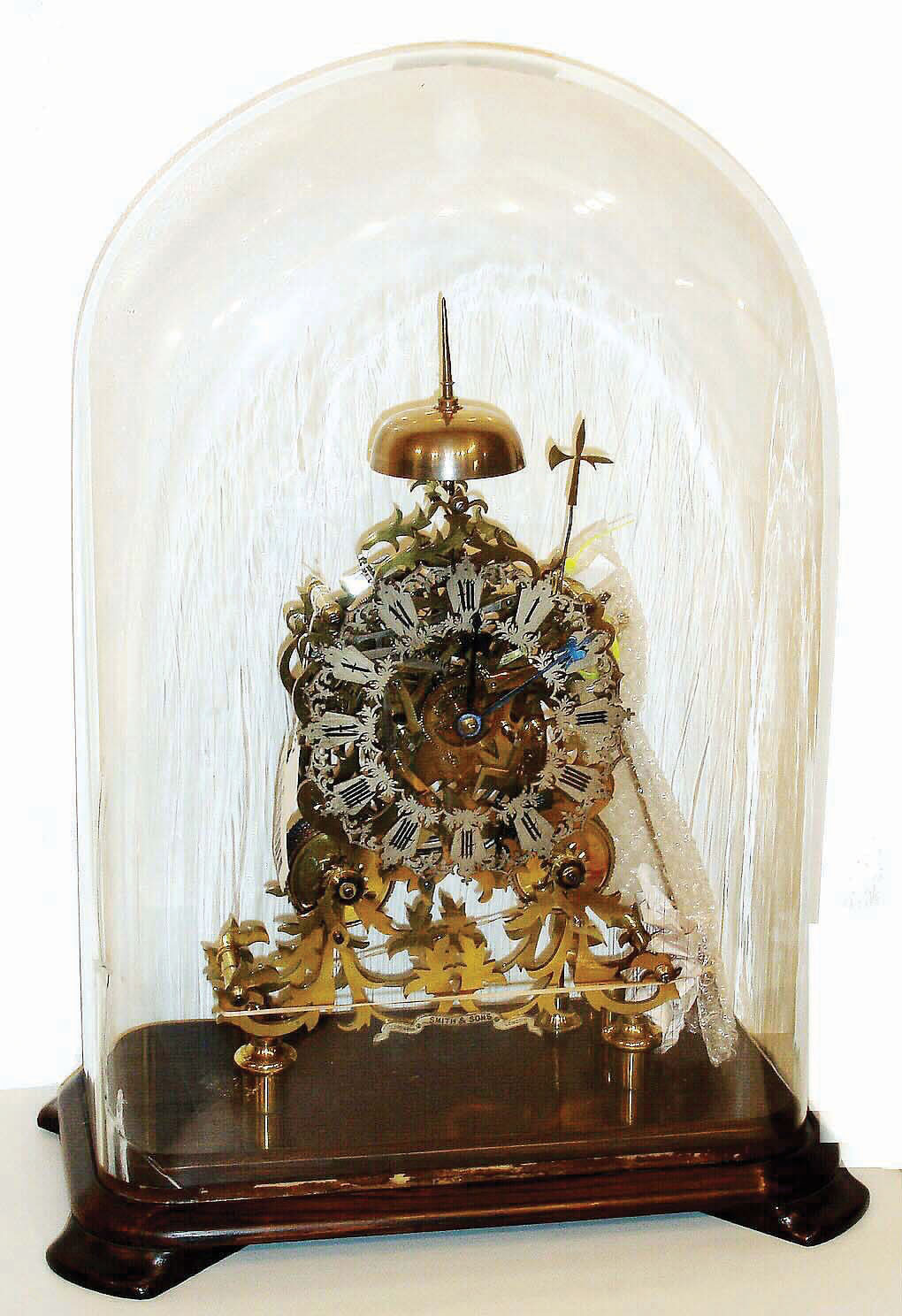 English, 2-fusee skeleton clock, striking full hours on a gong behind and half hours on bell, frame signed Smith and Sons on a small silvered brass plaque near bottom, the whole on a wooden base, c1875 — Antique Clocks Price Guide