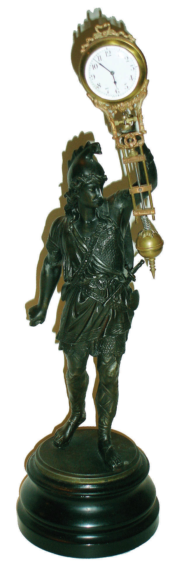 Swinger, bronzed cast metal classical soldier, on turned wood base, holding a German swinging clock, 20th century — Antique Clocks Price Guide