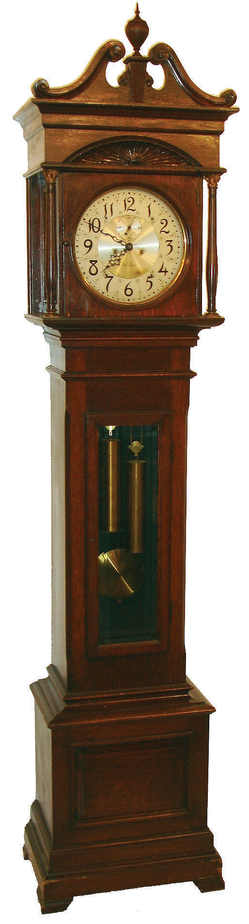 Seth Thomas Clock Co., Thomaston, Conn., "Hall Clock No. 23" tall clock, 8 days, time and bell strike, weight driven movement with deadbeat escapement in an oak case with turned and reeded columns with metal Corinthian caps, shell carving above dial and silvered round metal dial, c1906 — Antique Clocks Price Guide
