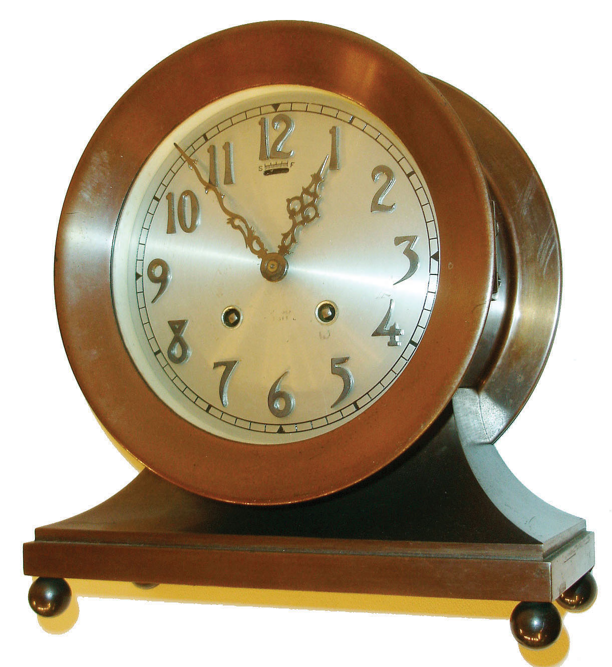 Chelsea Clock CO., Chelsea, Mass., "Commodore" model shelf clock, patinated bronze case with cavetto molded base on ball feet, 6" silvered dial with applied Arabic numerals, steel hands, marked "Chelsea Ships Bell", 8 day movement with ships bell striking, c1940 — Antique Clocks Price Guide