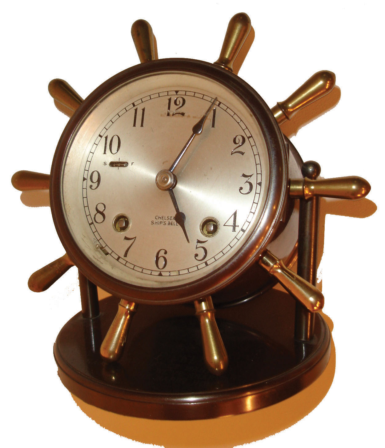 Chelsea Clock Co., Chelsea, Mass., "Vanderbilt" model table or desk clock, patinated brass case pivoting on supports mounted to the base, bezel with beveled glass, 4" silvered brass dial, blued steel hands, movement with ships bell striking, clock base engraved "Dave Bell In Memory of Many Happy Hours We've Shared, The Happy Hour", c1940 — Antique Clocks Price Guide