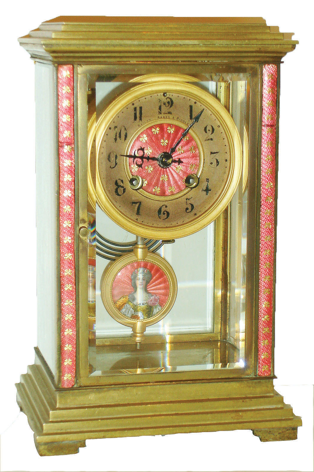France, crystal regulator, brass case with stepped base and top and with beveled glasses, the case front and dial center decorated with pink champleve enamel, the enamel ornamented with gilt shamrocks, gilt bezel, Arabic numeral gilt metal dial marked "Bailey, Banks &amp; Biddle Co.", 8 day time and strike pendule a Paris movement with Brocot escapement, the mark of Japy Freres, and also marked A1, striking on a gong, gilt pendulum with pink champleve enamel with portrait of a stylish young woman painted with opaque overglaze enamel, her dress in transparent orange and yellow enamels and backed with foil, c1910 — Antique Clocks Price Guide