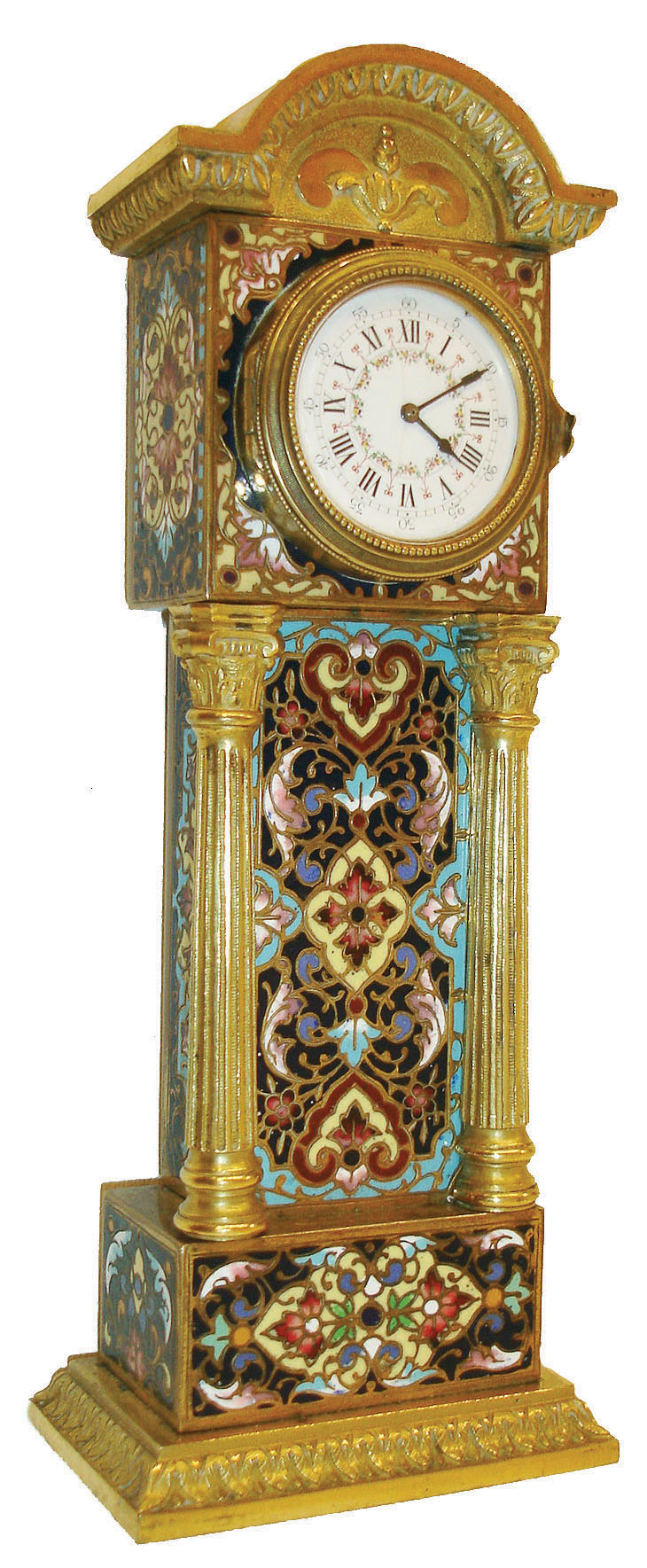 Desk clock, miniature tall clock form, gilt brass case with polychrome champleve enamel, egg and dart cornice, full Corinthian columns, and molded base with leaf decoration, beaded bezel with slightly convex glass, Roman numeral, white enamel dial with floral garlands and Arabic outer five minute markers, blued steel hands, and key wound 30 hour Swiss watch movement, c1900 — Antique Clocks Price Guide