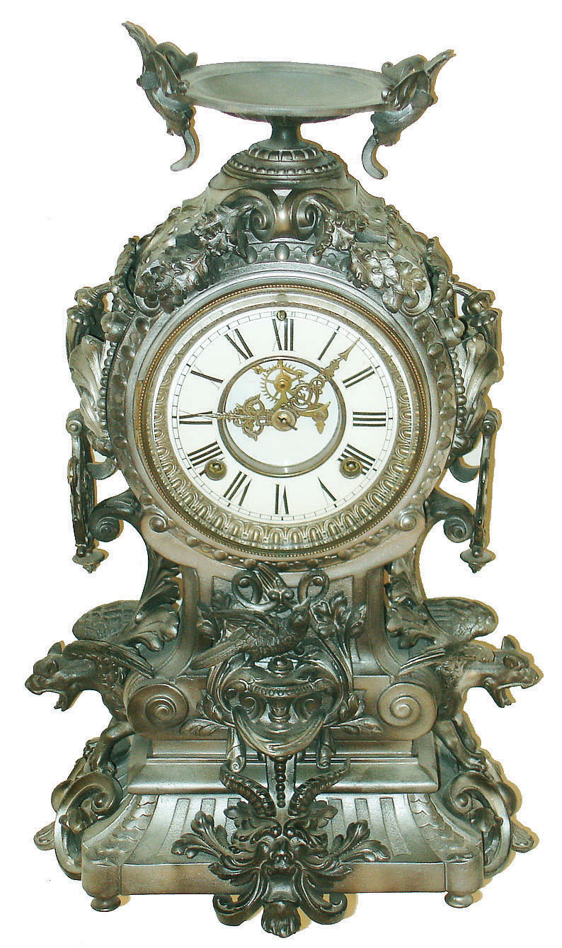 Ansonia Clock Co., New York, NY, "Franconia", cast metal fantasy clock, featuring flying gargoyles to the sides, a bird below the dial and profuse scrolls and swirls, surmounted by a winged urn, c1894 — Antique Clocks Price Guide