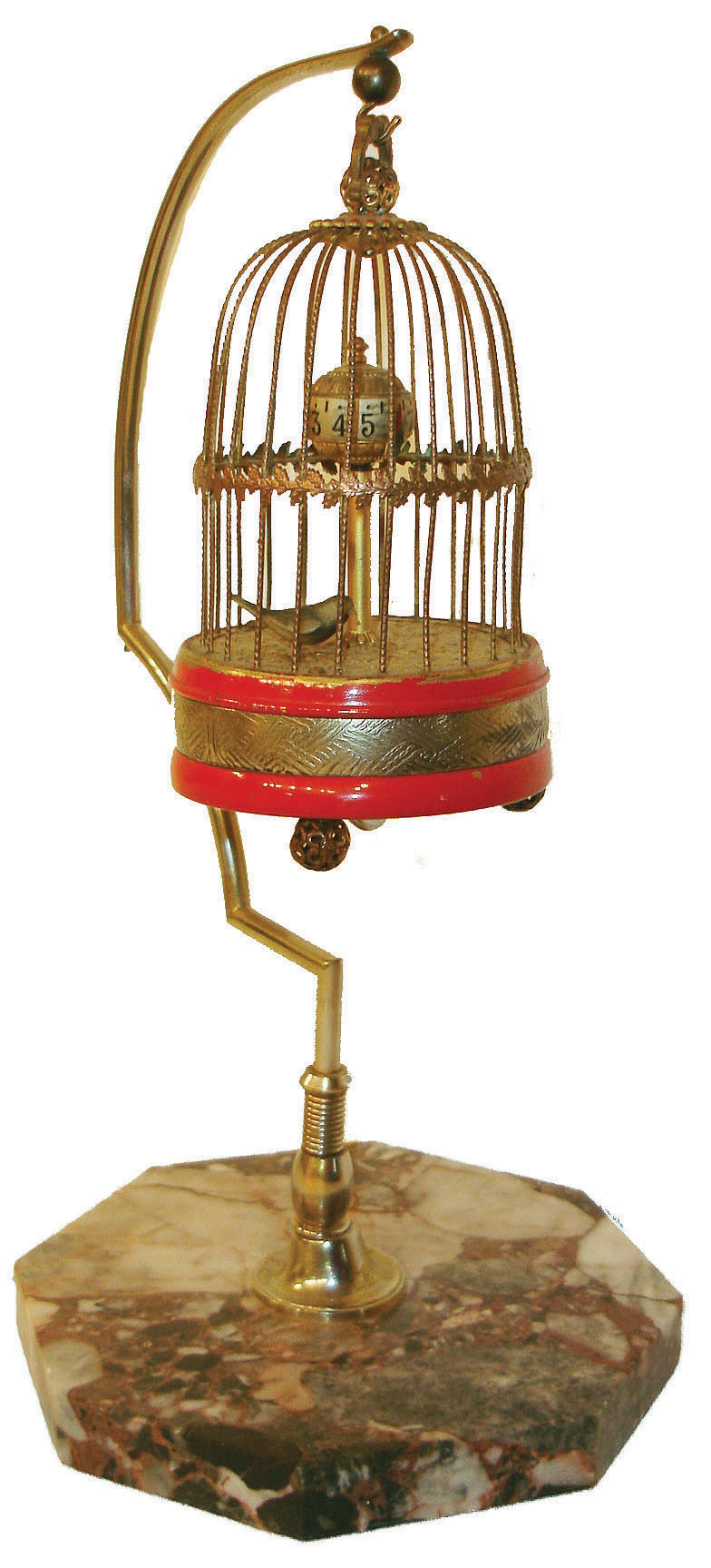 Toyo Clock Factory, Japan, bird cage clock, brass cage on red striped base with brass feet, rotating globe with pointer indicates time, bird attached to end of pallet arbor moves back and forth as clock ticks, the cage suspended from a polished metal hanger mounted to an octagonal marble base, c1930 — Antique Clocks Price Guide