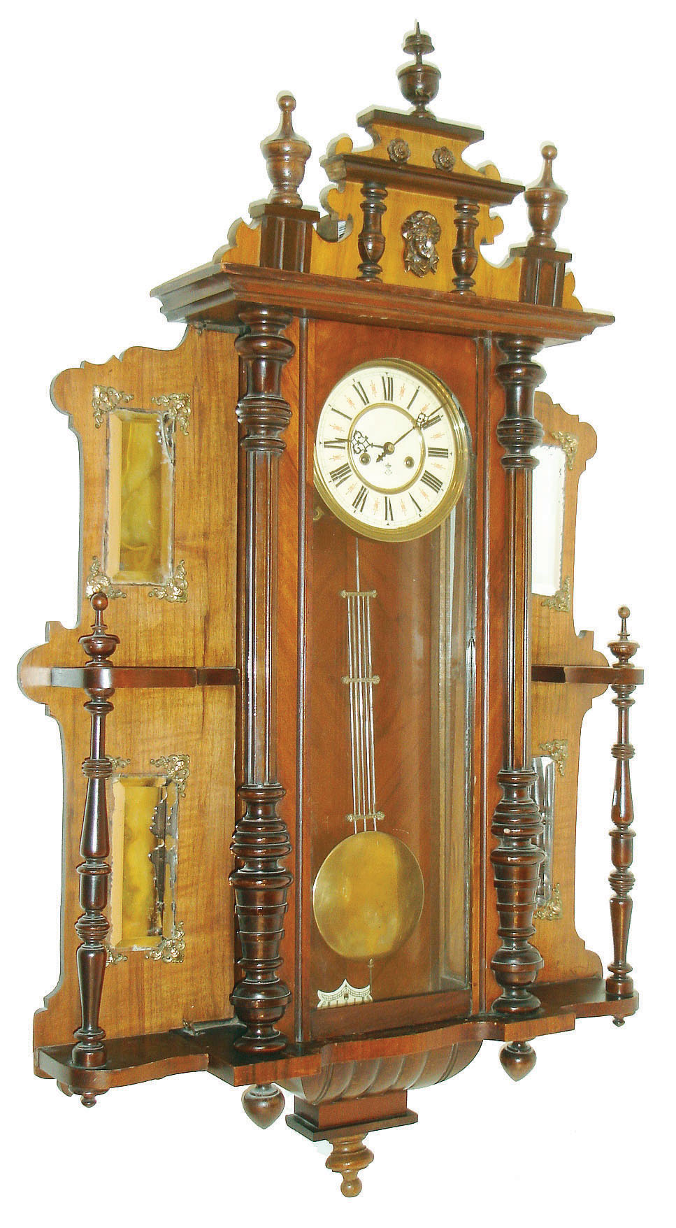 Gustav Becker, Silesia, Germany, "Vienna Regulator" wall clock, 8 days, time and gong strike, spring driven movement in a walnut case with turned half columns, mirrored side panels and top crest with Jenny Lind head and turned ornamentation.  The dial is multicolor enamel, c1880 — Antique Clocks Price Guide