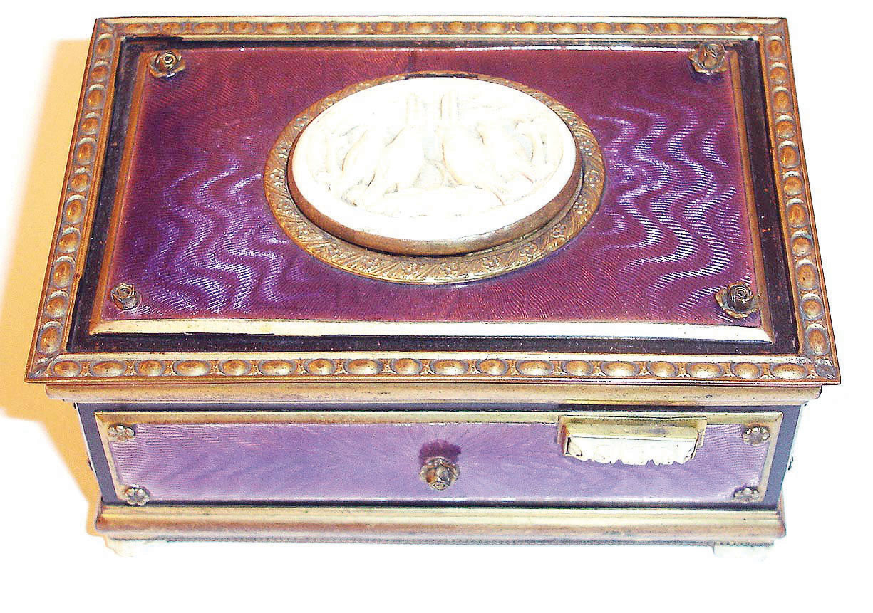 German, Singing Bird Box, key wound, actuated at will with slide on right front of case, the bird singing for his audience and then disappearing from view, from Karl Griesbaum factory, in a light violet guilloche enameled case with a carved ivorene cover over the bird and four ivorene feet, &amp; slide with 4 tiny roses, late 20th century. — Antique Clocks Price Guide