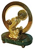 Devon Clocks Ltd., England, mystery clock, design based on John Schmidt's 1808 patent "The Mysterious Circulator or Chronological Equilibrium", the pivoted indicator with a pointer on one end, and the larger cylinder at the other containing the movement with revolving weights, all suspended between two gilt mermaid form supports, Roman numeral silvered chapter ring, on a green marble base with ball feet, base with brass plaque marked "Devon Clocks Ltd. 134/1500, c1980