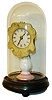 Candlestand clock, porcelain stand with pink band and striping at base, electroformed copper dial surround, Roman numeral white paper dial, steel spade hands, 30 hour timepiece movement, all under a glass dome and mounted to an ebonized, turned wooden base on ball feet, c1860