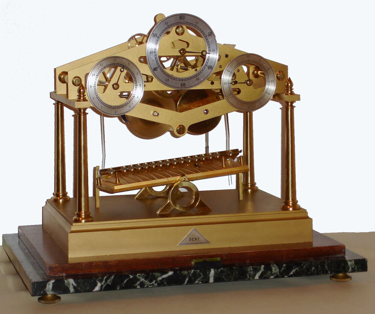 Dent, London, England, "Congreve Rolling Ball Clock", 8 day, spring driven, fusee movement with maintaining power is regulated by a rolling steel ball traversing an inclined plane every 15 seconds, tripping a lever, tilting the plane in the opposite direction, while registering 15 second intervals on the right dial, minutes on the center and hours on the left all on a marble base in a Plexiglas case, dated 1973 — Antique Clocks Price Guide