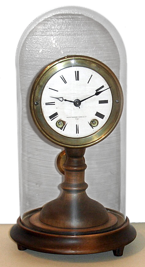 Seth Thomas Sons and Co., Thomaston, Conn., "No. 5002" or candlestick mantel clock, 8 day, time and bell strike, spring driven movement with porcelain dial. wooden turned candlestick style base and glass dome, c1875 — Antique Clocks Price Guide