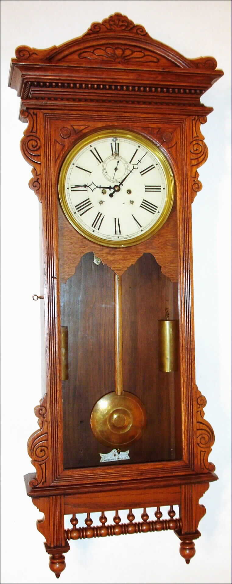 Waterbury Clock Co., Waterbury, Conn., "Regulator No. 57" wall clock, 8 day, time only, two weight driven movement in an oak case with painted metal dial, c1906 — Antique Clocks Price Guide