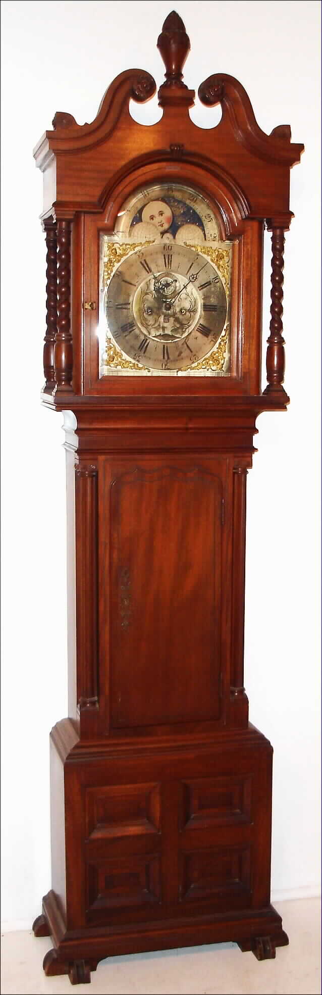 Walter Durfee, Providence, Rhode Island, "Tall Case" clock, 8 day, time, strike moon phase and calendar, weight driven movement in a mahogany case with four rope twisted columns on hood and large ornately carved finial, string brass inlay on door and trunk flanked by fluted columns on trunk over a base with four recessed panels and stylized shoe feet. The silvered brass dial has raised plaque with Durfee signature, four cast brass spandrels, raised Roman numeral chapter ring and engraved floral dial center, c1880 — Antique Clocks Price Guide