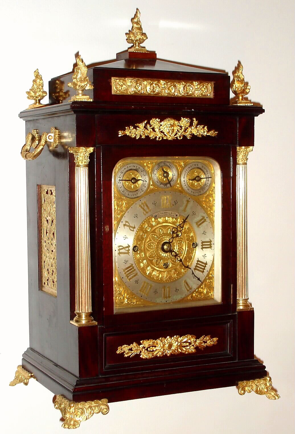 English, first class maker, for J. E. Caldwell, Philadelphia, a triple fusee, 8-Bell and Westminster on gongs, bracket clock, chiming the quarters on your choice of bells or gongs, and counting the hours on a large flat wire cathedral gong, the cushion top dial with applied gilt Roman numerals, and with subsidiary dials for F/S, Chime-Silent, and choice of tune; case with profuse ormolu trim, c1890. — Antique Clocks Price Guide