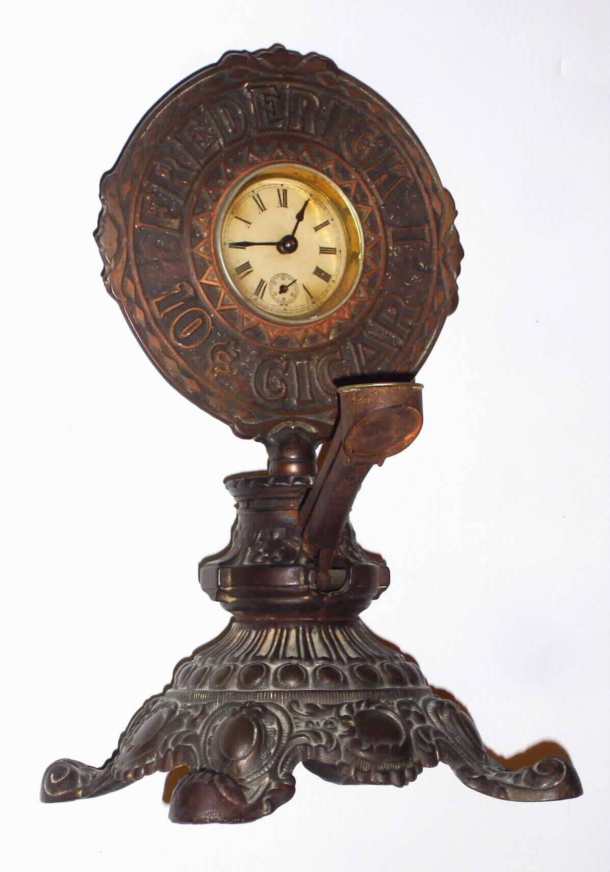 Waterbury Clock Co, Waterbury, Conn., advertising cast metal 30 hour time piece and "Frederick Cigar" cutter, c1910 — Antique Clocks Price Guide