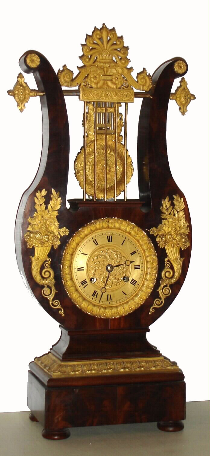 French lyre form mantel clock, spring powered eight day time and strike movement, visible gilt brass gridiron pendulum with acanthus and swan decoration suspended above the movement, Roman numeral dial with painted figures, the case veneered in good quality figured mahogany, decorated with classically themed gilt bronze mounts, including anthemion, scrolls, overflowing cornucopia, laurel, parsley and waterleaf, c1825 — Antique Clocks Price Guide