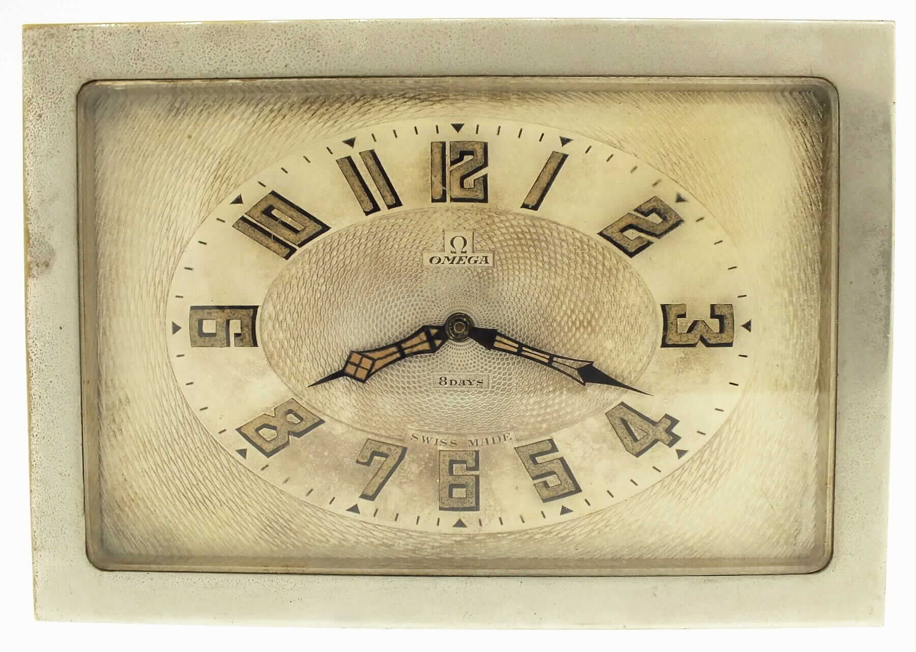 Omega Watch Co., Switzerland, rectangular desk clock, polished nickel finish, spring powered eight day time only movement, silvered guilloche dial with smooth Arabic chapter, dial signed Omega Swiss Made 8 days, luminous blued steel hands, beveled glass front, c1930 — Antique Clocks Price Guide
