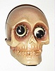 Oswald Uhrenfabrik, Germany, "Skull" rotating eye time piece, 30 hour, time only, spring driven movement in a composition case with grey skull and brown eyes, c1930