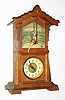 Junghans, Germany, "Acrobat" model novelty, with automated figure, spring powered thirty hour two train movement, one train for time, the other for the performer, oak case with original finish, acrobat on trapeze in front of lithograph scene of the interior of a circus tent with spectators, Junghans logo at lower right, coated paper dial with Arabic figures, dial trim and center in polished, lacquered brass, blued steel hands,