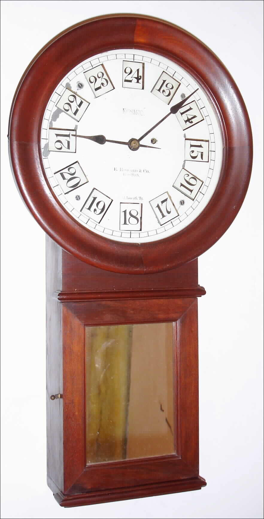 E. Howard and Co., Boston, Mass., "Kosmic" wall clock version of the Regulator No. 70", 8 day, time only, weight driven movement adapted to display 24 hours with Roman numerals, 1 - 12, and Arabic numerals, 13 - 24, on twelve painted rotating wooden blocks.  The walnut case is stamped "14" on the top of the case and wooden bezel with a painted metal dial signed "KOSMIC E. HOWARD and CO. BOSTON Pat'd June 9th '85", c1886 — Antique Clocks Price Guide