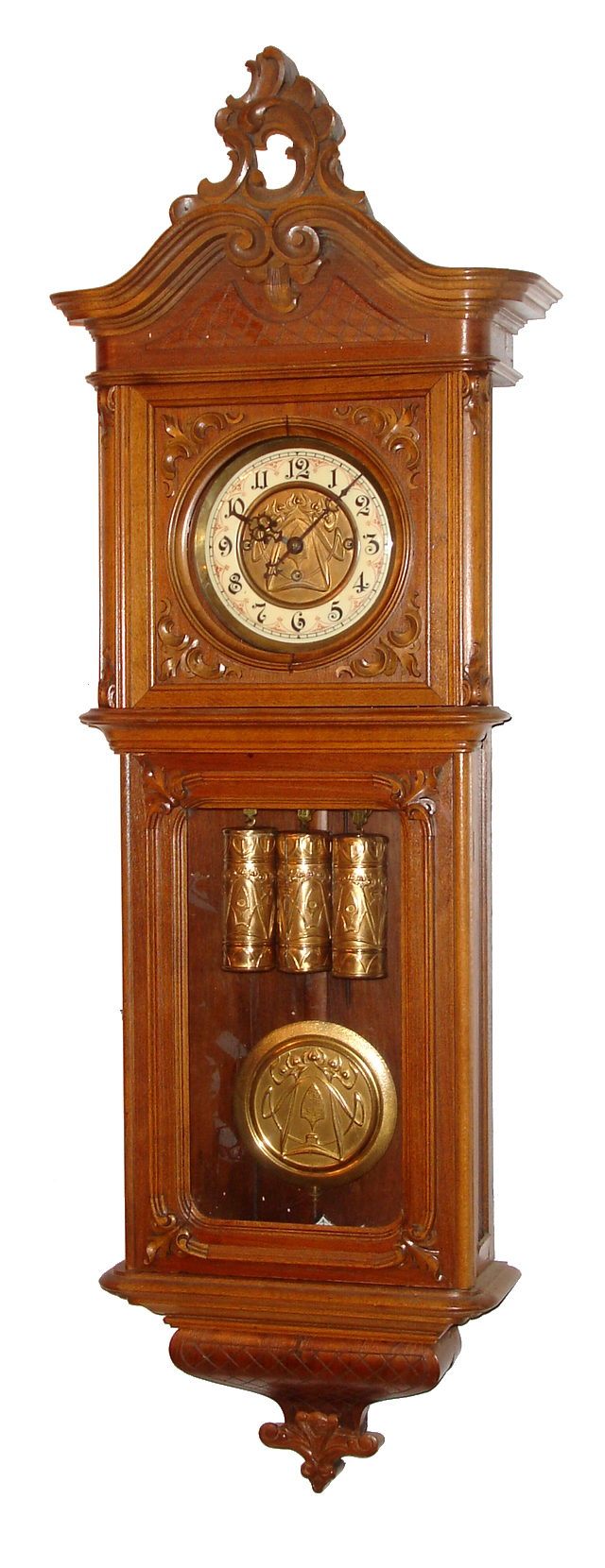 Gustav Becker, Freiburg, Germany, "Vienna Regulator in Baroque Style" wall clock, 8 day, time and Grande Sonnerie strike, three embossed weight driven movement with embossed pendulum bob in a walnut case with carved top and other applied carvings.  The multicolor and white enamel dial is inset with embossed brass center, c1880 — Antique Clocks Price Guide