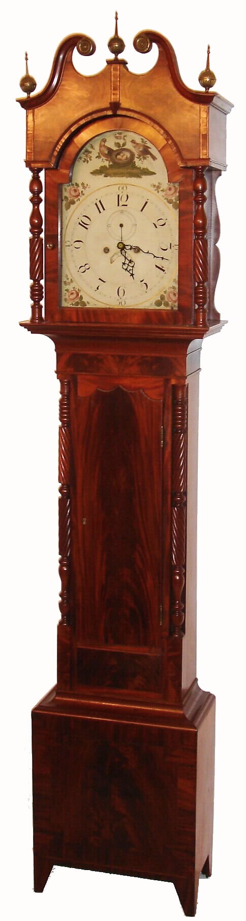 New York state tall clock, 8 day, time and bell strike, weight driven movement in a mahogany and mahogany veneer case with crotch mahogany door and plinth, turned full columns with urn and twist design flanking both hood and trunk door and cross banded broken arch pediment with brass rosettes and finials.  The painted iron dial is decorated with roses, two birds and nest and has date aperture and second's bit, c1830 — Antique Clocks Price Guide