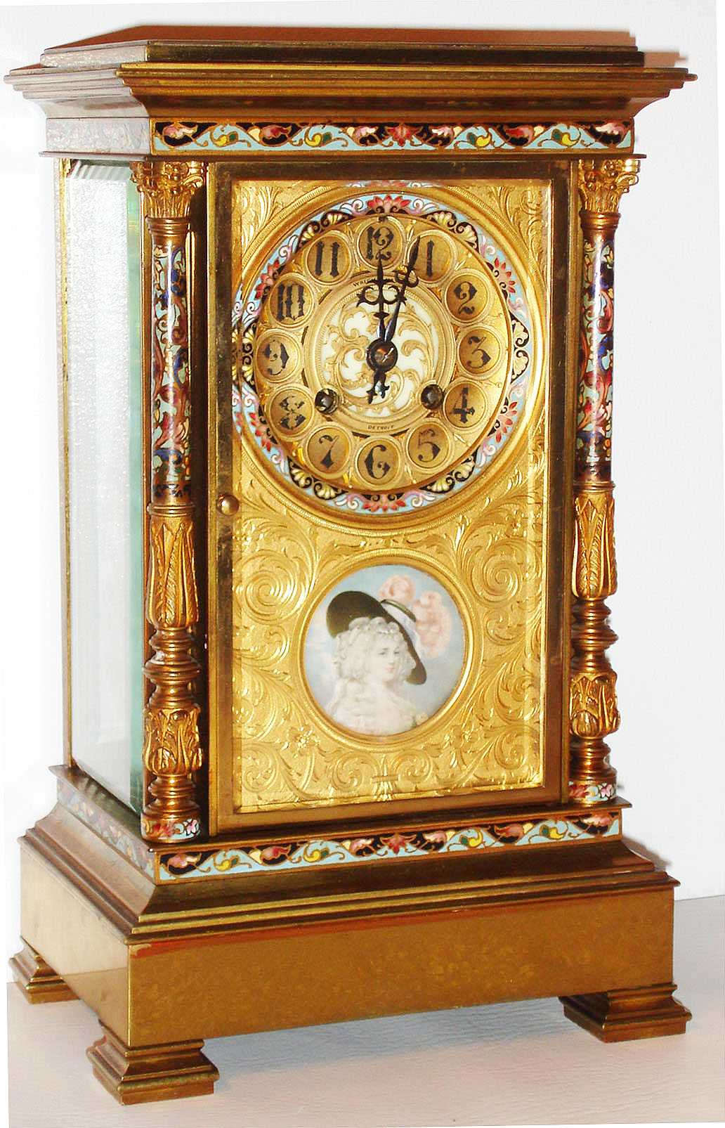 France, for Wright, Kay and Co., Detroit, eight day time and strike crystal regulator in a large size, polished brass case with columns, columns and case with champleve enamel ornament, gilt dial mask decorated with engraved acanthus leaf on a matted ground, pierced and engraved gilt dial with Arabic numerals and champleve border, with a well executed portrait miniature of a fashionable young woman below the six, blued steel hands, four beveled glass panels, round French movement with Brocot escapement, striking the hours and half hours on a gong, mercury pendulum c1880 — Antique Clocks Price Guide