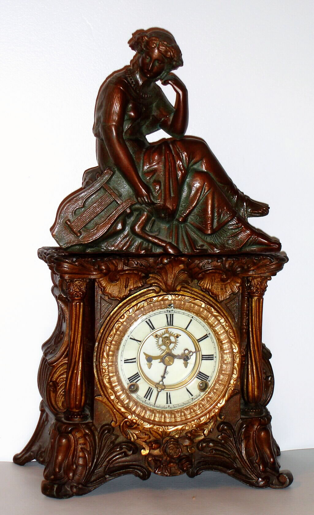 Ansonia Clock Co., New York, NY, "MINERVA" and figure, cast metal mantle clock, dial with open escapement.  Note the Minerva name had been used on a different model in 1874, this model c1904 — Antique Clocks Price Guide