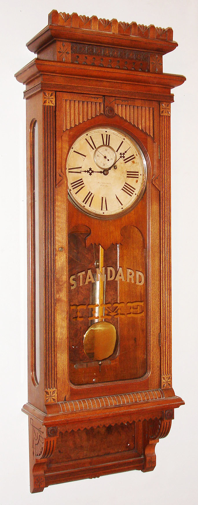 Wm. L. Gilbert Clock Co., Winsted, Conn., "Regulator No. 10" variant wall clock, 8 day, time only, weight driven movement in a walnut case with paper dial and "STANDARD TIME" stencil on lower tablet, c1901 — Antique Clocks Price Guide