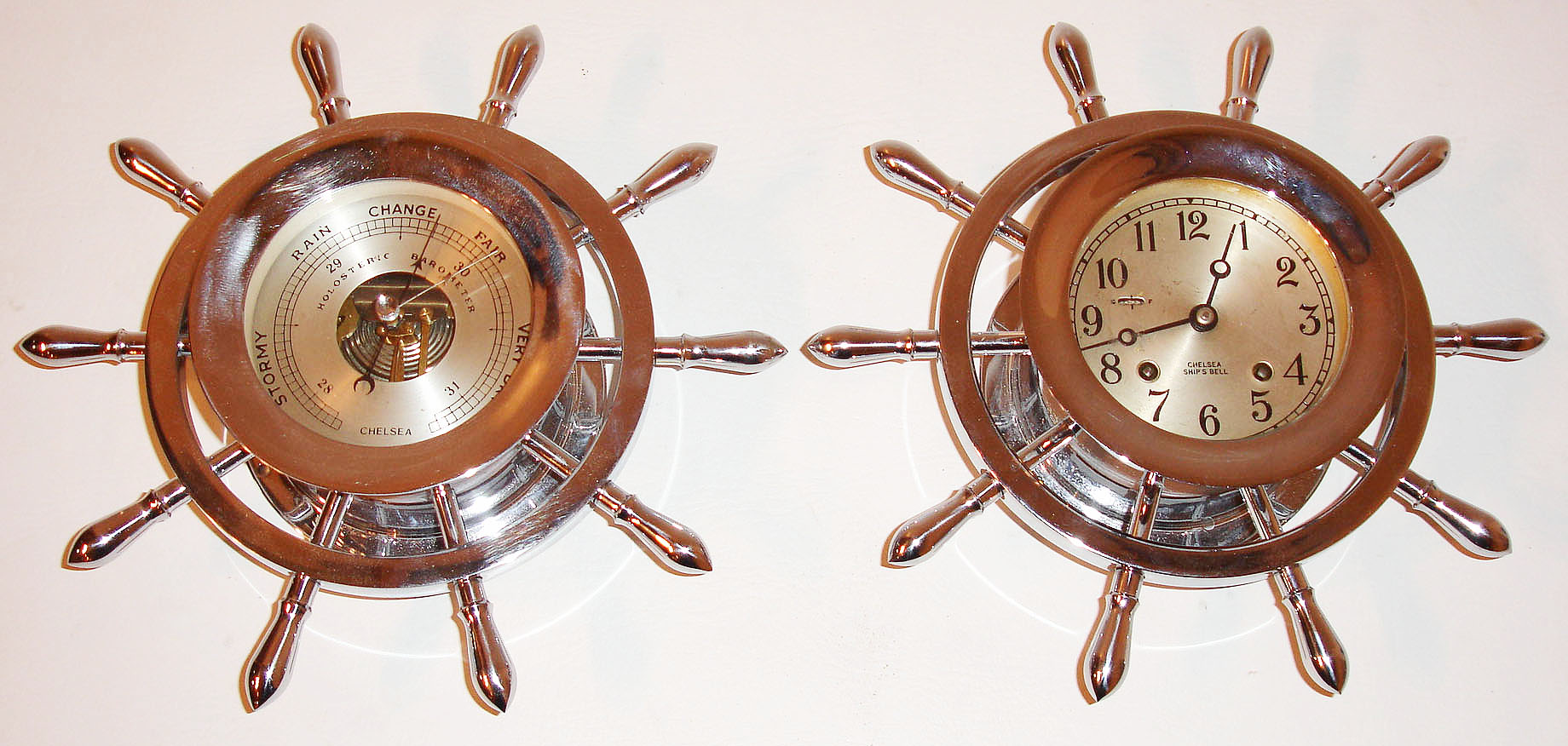 Chelsea Clock Co., Boston, Mass., ships bell clock and barometer in polished nickel finish yacht wheel cases, eight day time and ships bell strike movement with silvered Arabic numeral dial, black finished steel moon hands, the barometer with matching case and silvered dial, and blued steel hand, c1975 — Antique Clocks Price Guide