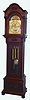 Tiffany and Co., New York, 5 tube hall clock, 8 day, time, strike and chime, three weight driven English movement, Elliott design, playing single tune [Westminster] on tubes signed by Walter Durfee with patent date 1887 in mahogany case on bun feet with two full bold columns flanking trunk, beveled glass door in trunk and three ornately carved sunbursts on top of hood, above trunk and on panel in base.  The brass arched dial has a silvered chapter ring with applied brass numerals, surrounded by a finely engraved foliate mask, turned spandrels and dial center, moon phase, selection for chime or silent, and second's bit, c1905