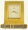Cartier, Paris, France, small desk or nightstand clock, 15 jewels, key wind and set, gilt plate movement, with lever escapement, in an 18 karat, yellow gold, straight line engine decorated case, and silver dial with gold pyramid markers, gold dauphine hands, serial #658, 341.9g TW c1975, with original key, L 2 1/2" W 1 5/8" Ht 2 3/4"
