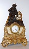 French, ormolu, bronze and marble cased mantel clock, bell strike, 8-day, depicting a young Spanish explorer, seated in a pensive pose, the dial showing below and flanked by white marble and profuse floral garlands, c1850