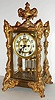 Ansonia Clock Co., Brooklyn, N.Y., "Marchionesse" model crystal regulator, polished brass case with ornate gilt ornament, beveled glasses, white enamel Arabic numeral dial, blued steel hands, 8 day, time and strike, movement with round plates, Brocot open escapement, gilt simulated mercury pendulum c1905