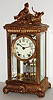 Seth Thomas Clock Co., Thomaston, Conn., "Empire No. 14" model crystal regulator, polished gilt case with gilt ornament, hunting scene at top, beveled glasses, white enamel Arabic numeral dial, blued steel hands, 8 day, time and strike, movement with round plates, gilt simulated mercury pendulum c1905