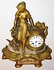 France, bright and matte gilt figural spelter and alabaster mantel clock, the female figure leaning against the clock case, and looking down at two birds, the base with acanthus, bellflower and fasces ornament, and an alabaster panel in the front with gilt ornament, white enamel Roman numeral dial with Breguet style hands, 8 day, time and strike, pendule a Paris movement, the case back signed "Ph. Mourey", c1870