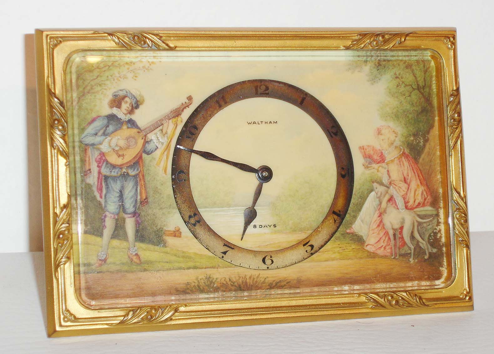 Waltham Watch Co., Waltham, Mass., desk clock, 8 days, time only, spring driven movement in a gilt frame case with painted dial depicting troubador courting a lady, c1910 — Antique Clocks Price Guide