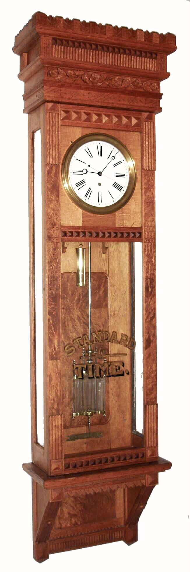 William L. Gilbert Clock Co., Winsted, Conn., "Regulator No. 12 Hanging" wall clock, 8 days, time only, weight driven Swiss movement with a three glass vial mercury pendulum, sweep seconds and pinwheel escapement in an oak case with white enamel dial and glass displaying "STANDARD TIME", c1895 — Antique Clocks Price Guide