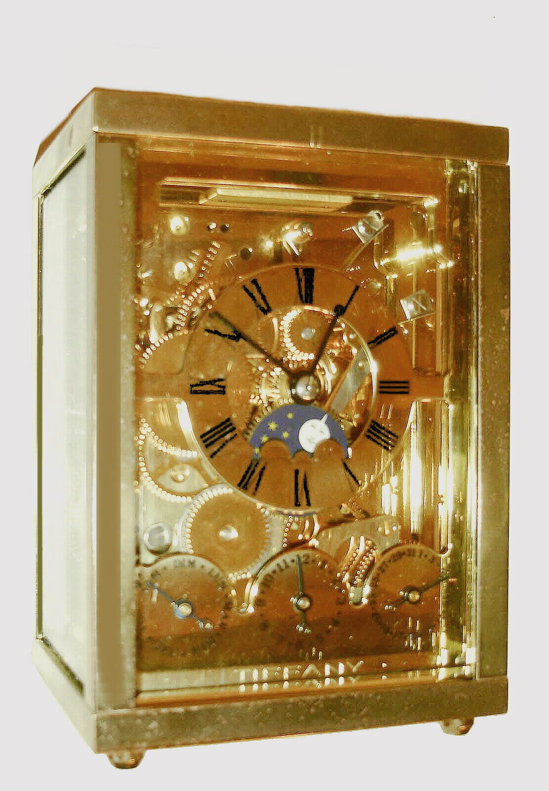 L'Epee, France, for Tiffany, 8 days, carriage clock with calendar, phases of the moon, and alarm, striking the hours and half hour on a gong, plain rectangular polished case, back and sides with beveled glasses, skeletonized, polished brass time, calendar and alarm dials with blued steel hands, gilt lever escapement platform with matte finish, c1980 — Antique Clocks Price Guide