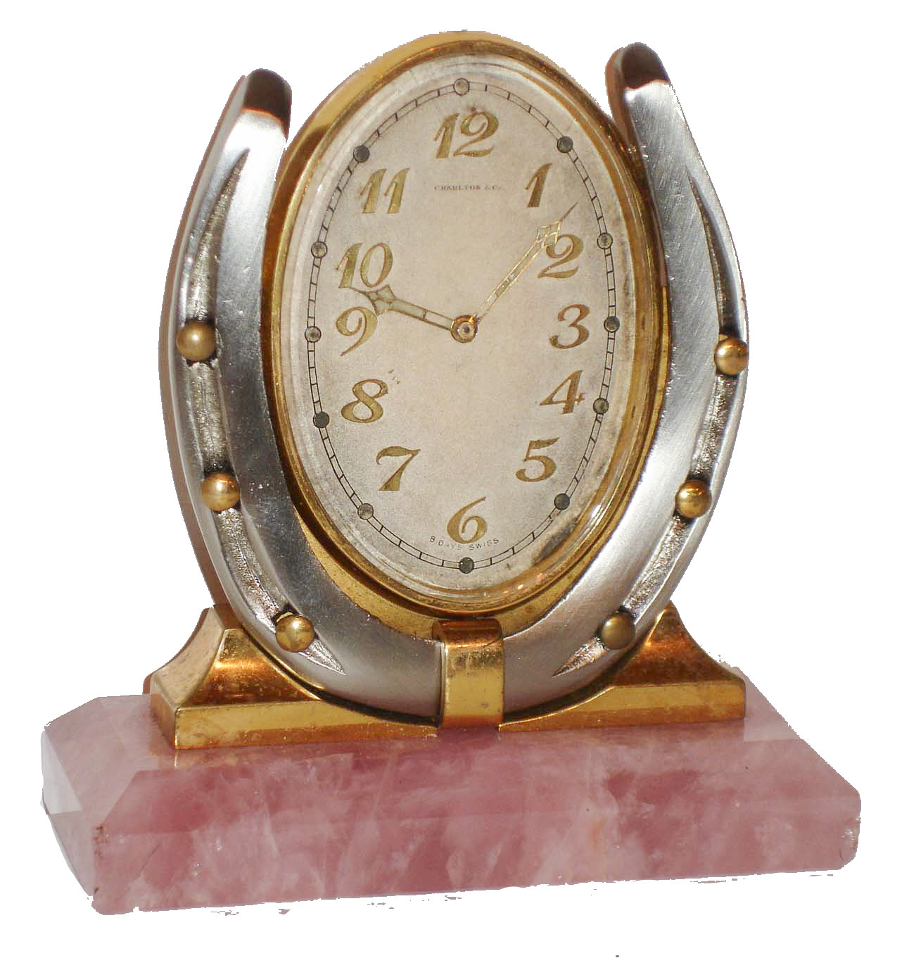 Desk or nightstand clock, polished rose quartz base supporting a silvered horseshoe with gilt nails, and an oval framed, silvered dial clock with gilt Arabic numerals, the dial signed "Charlton &amp; Co. 8 days, Swiss" with gilt, luminous hands, nickel 15 jewel movement signed "Concord Watch Co", c1920 — Antique Clocks Price Guide