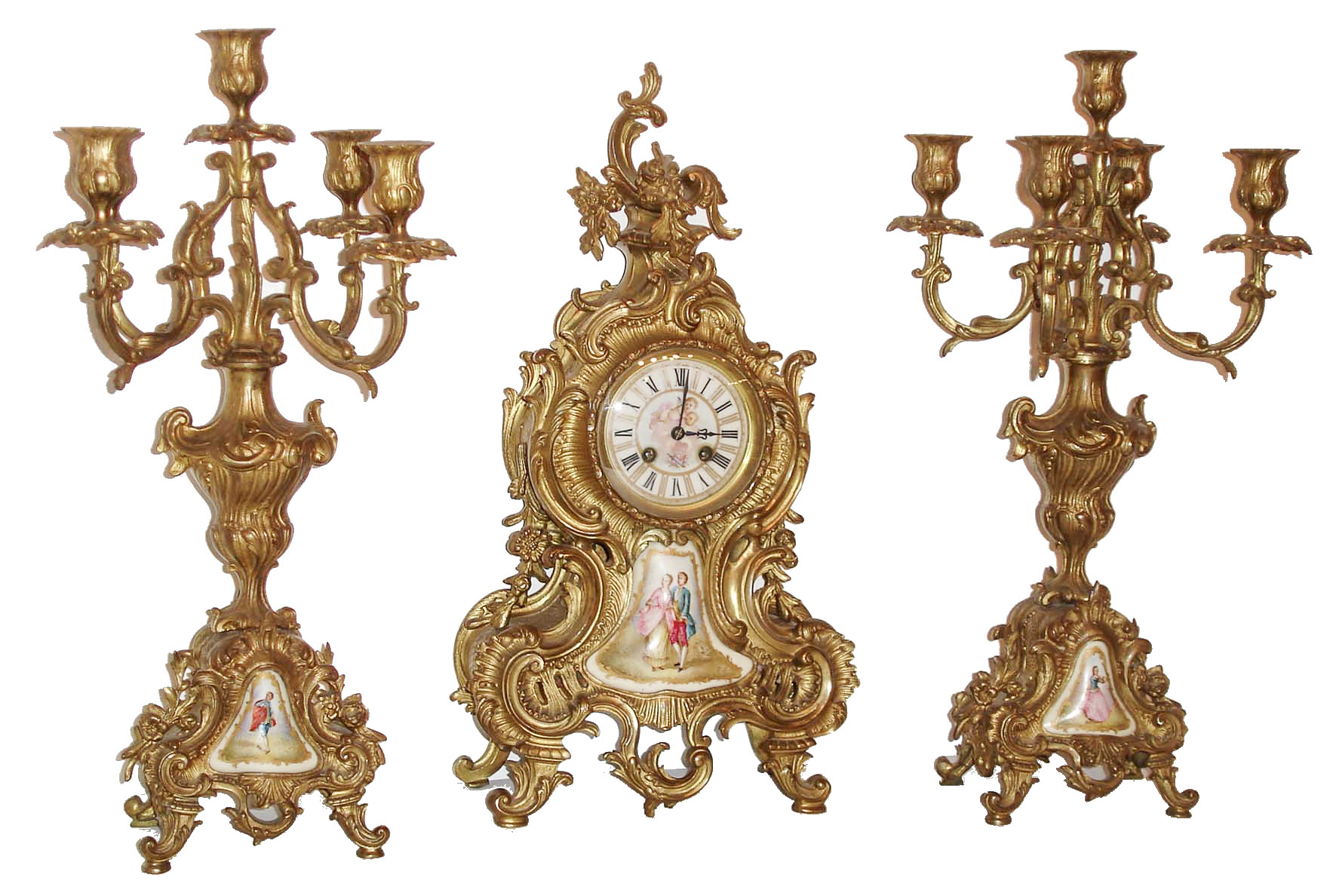 France, 3 piece mantel garniture in gilt brass, the clock and candelabra in the rococo style, heavily laden with foliage and C scrolls, the case front with inset polychrome enamel decorated porcelain panel featuring a man and woman in fancy dress, Roman numeral porcelain dial with gilt chapter and cupid at the center, the gilt candelabra similarly ornamented, but each with a single figure, and 8 days, time and strike, pendule a Paris movement by Japy Freres, c1910 — Antique Clocks Price Guide