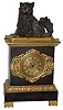 French gilt and patinated bronze 8 days, time and strike, mantel clock, with a bronze figure of a grooming cat sitting on a pillow, the cat with nodding head, c1830, the dark patinated case with gilt trim decorated with acanthus and anthemion, gilt metal dial with engine turned center and black painted Roman numerals, Breguet style hands, and dial trim in the Grecian taste, the pendule a Paris movement with silk thread suspension striking the hours and half hours on a bell, the cat seated on a gilt pillow licks his paw as his head nods powered by a separate movement wound through the left side of the case
