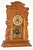 Attleboro Clock Co., Attleboro, Mass., "Improved Royal Assortment -C", 8 day, time and strike, Pressed oak kitchen clock. This was a firm that had clocks made and retailed by them.  Firms such as Ansonia, Waterbury and Ingraham supplied them with clocks, c1900