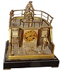 French industrial "Ships Stern" clock by Guilmet, signed 8 days, time and strike, movement mounted in a silvered and gilt case representing a ships quarter deck, the captain rocking back and forth at the wheel as the upper part of the compound pendulum, with knife edge suspension, deck railing with gimbaled lamps, and a sailor coiling rope below, gilt Roman numeral dial with blued steel hands, all on a black slate base with gilt feet, c1885