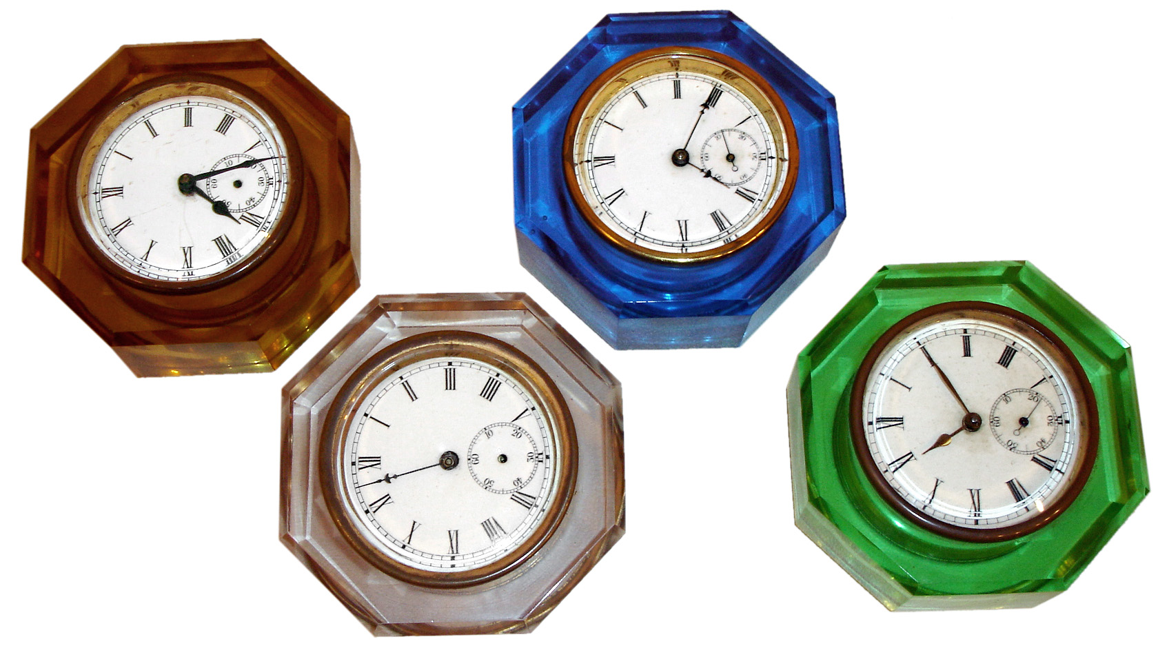 Clocks- 4 (Four): E. N. Welch Mfg. Co., Forestville, Conn., "Jewel", 8 days, colored glass paper weight clocks, c1886 (1)Green glass case. (2)Clear glass case. (3)Blue glass case. (4) Amber glass case. — Antique Clocks Price Guide