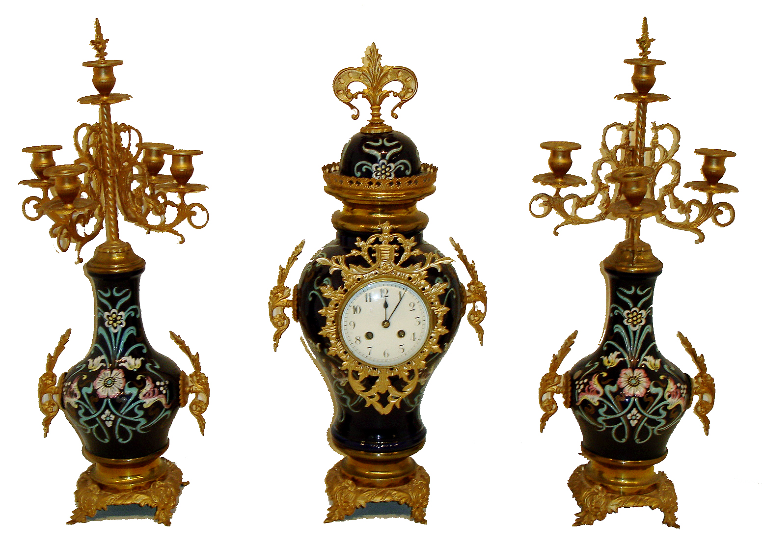 French, 3-piece mantel clock set, porcelain urn shaped case with matching torchier/candle stand side pieces.  The 3 porcelain pieces are cobalt blue with light blue and pink decorations in the Nouveau style. The time and strike, movement with a platform lever escapement, seems intact, c1905 — Antique Clocks Price Guide