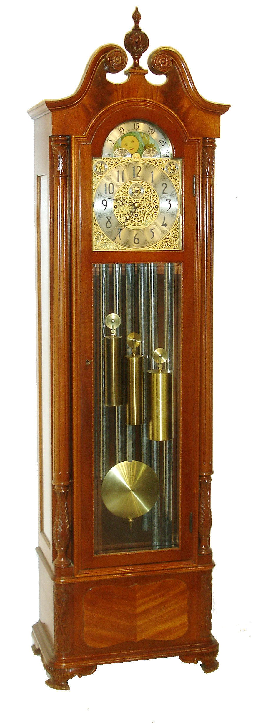 Herschede Clock Co., Cincinnati, Ohio, Colonial style 9 tube hall clock, 8 days, time, strike and chime, three weight driven movement playing three tunes, Westminster, Wittington, Canterbury in a mahogany case with fluted full Corinthian columns on sides, bracket feet and beveled glass on trunk and sides. and herring bone panel on base. The silvered dial has applied brass Arabic numerals, brass corner and center spandrels and moon phase, c1960 — Antique Clocks Price Guide