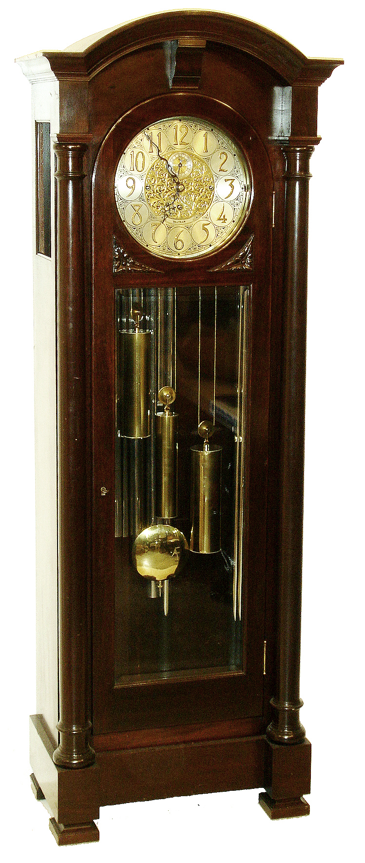 Waltham Clock Co., Waltham, Mass., "No. 983" tall clock, 8 days, time, strike and Westminster chime on 5 tubes, three brass weight driven movement in a mahogany case with full capped columns and silvered brass dial with reticulated brass center, c1920 — Antique Clocks Price Guide